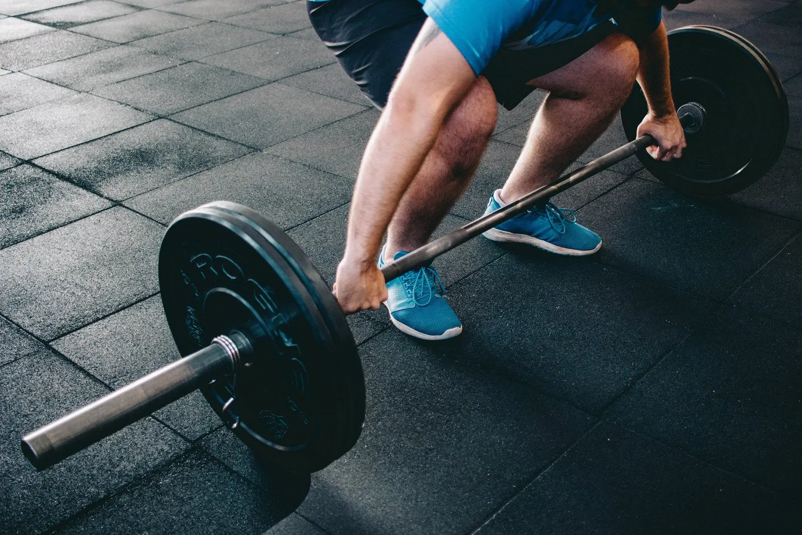 A group of athletes in a CrossFit class, mid-workout, looking focused and strong.