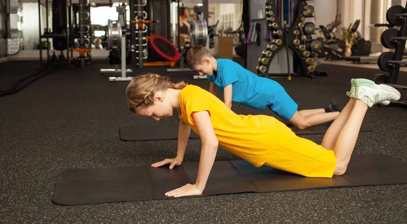 A group of children smiling and participating in a fun CrossFit Kids class.