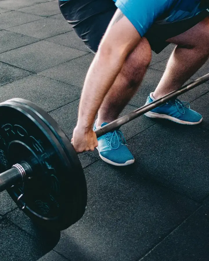 A group of athletes in a CrossFit class, mid-workout, looking focused and strong.