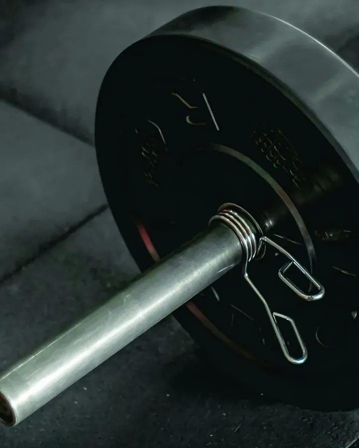 A loaded barbell resting on a gym floor.