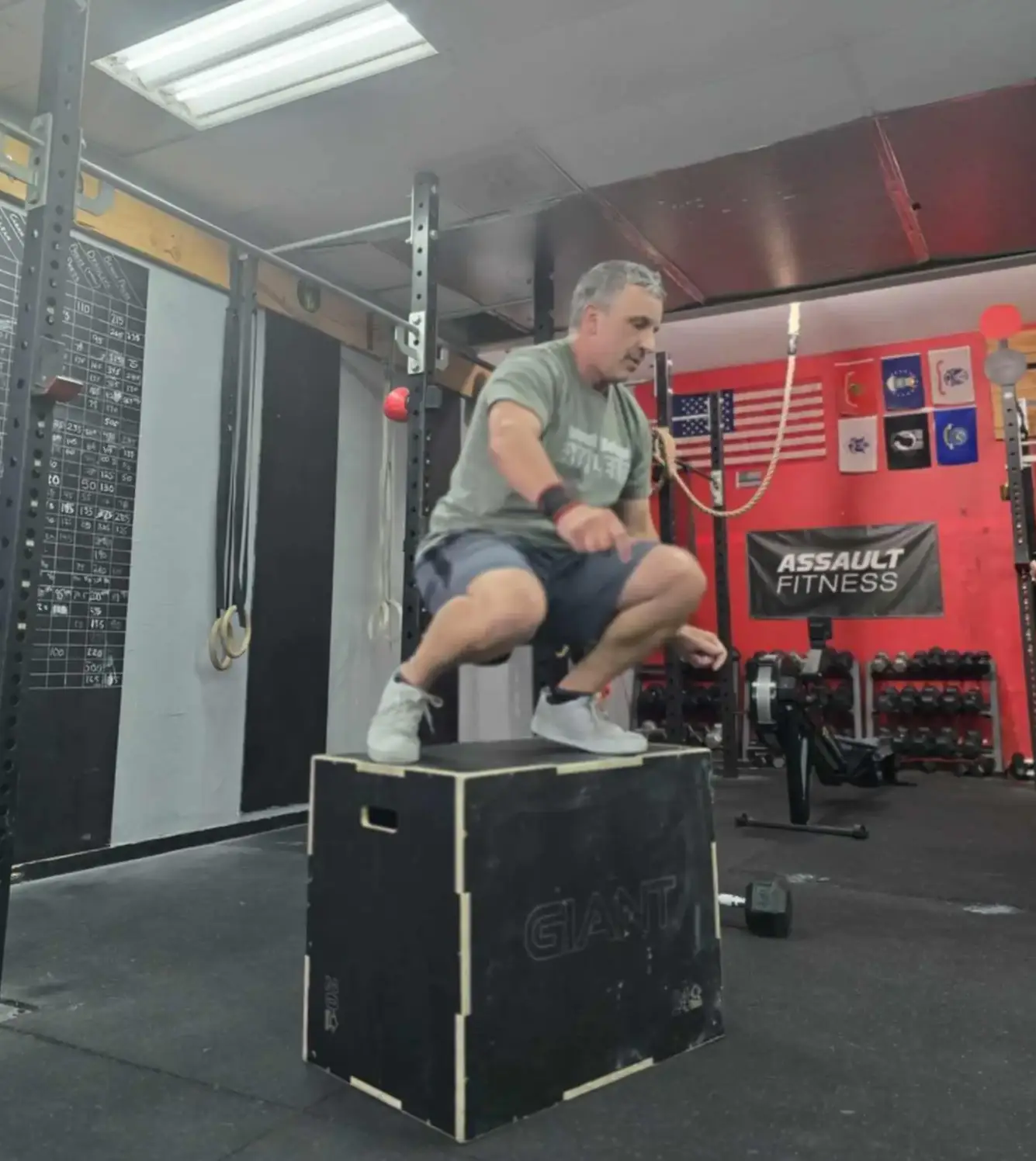 A coach giving a high-five to a smiling member after a challenging workout, illustrating the supportive and encouraging atmosphere at CrossFit Deluge.