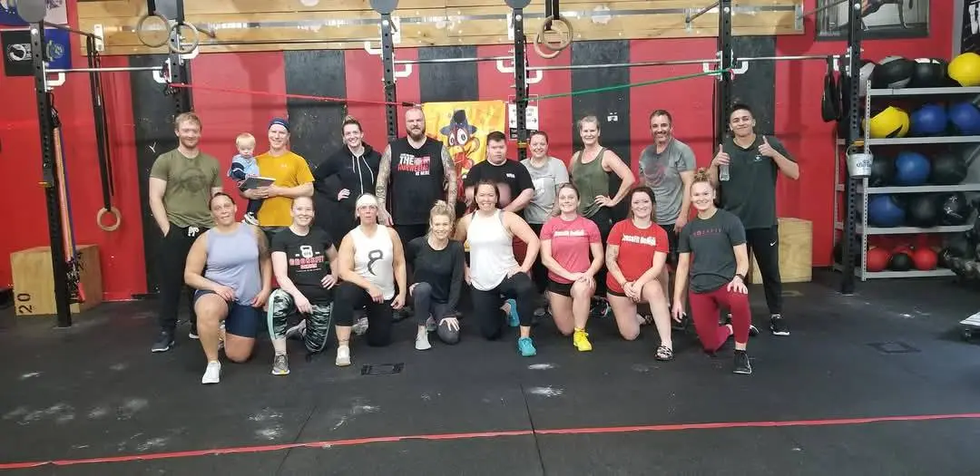 CrossFit Deluge community members of all ages and fitness levels celebrating together after a successful workout