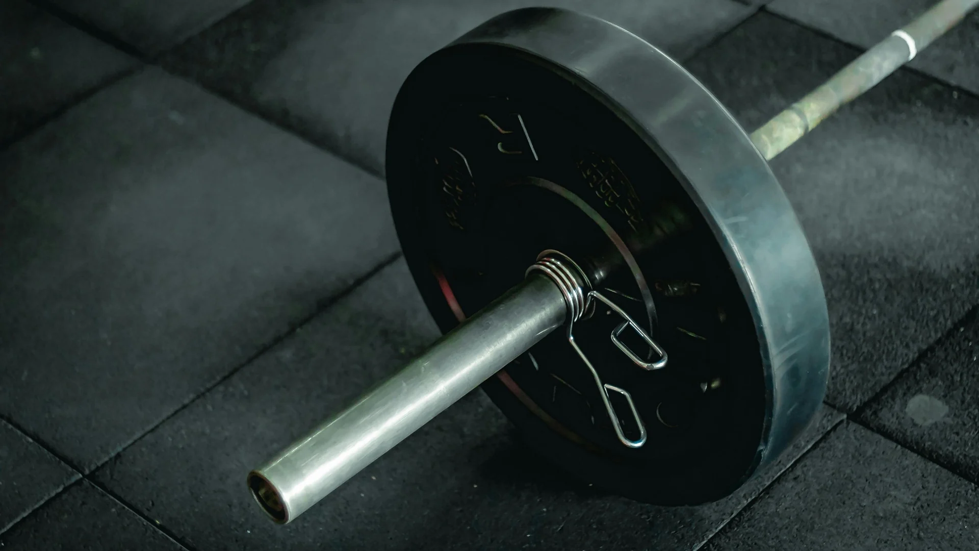 A loaded barbell resting on a gym floor.